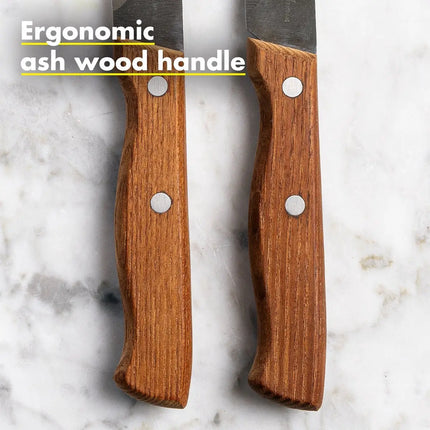 Close-up van ergonomisch essenhouten handvat van GreenPan steakmes met metalen klinknagels op marmeren ondergrond