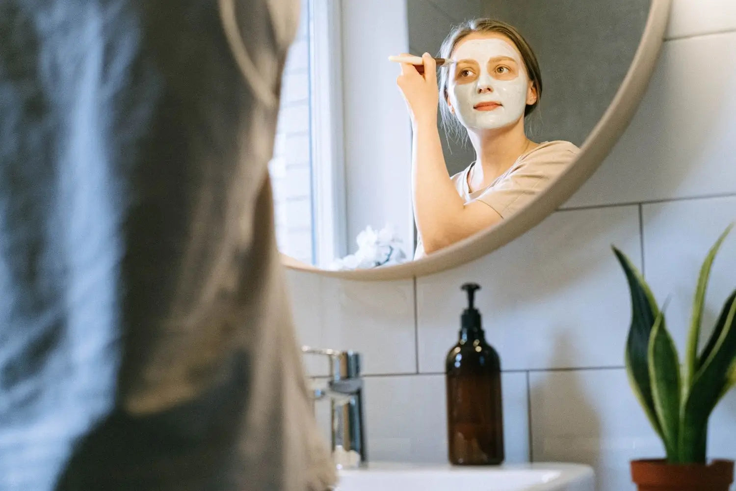 Vrouw brengt een kleimasker aan op haar gezicht