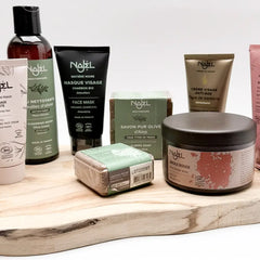 Producten van Najel met Aleppo‑zeep en biologische verzorging, gepresenteerd in een rustige opstelling.