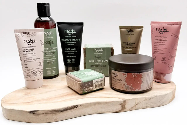 Producten van Najel met Aleppo‑zeep en biologische verzorging, gepresenteerd in een rustige opstelling.