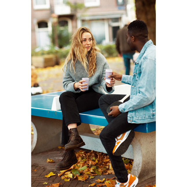 Twee mensen gebruiken de duurzame BE O Bottle van suikerriet in een ontspannen setting – herbruikbare waterfles voor onderweg