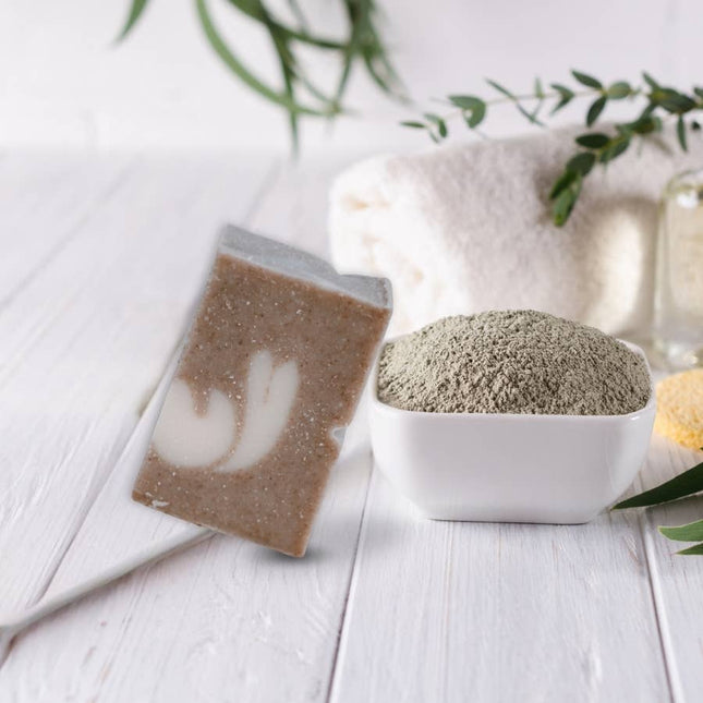 Vaste biologische shampoo tegen droog haar, gestyled met witte klei, handdoek en groen op houten ondergrond. Natuurlijke verzorging in spa-sfeer.