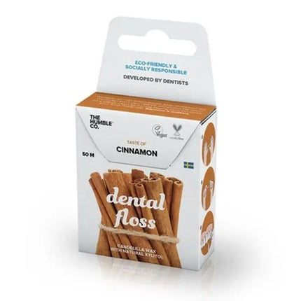 Detail van verpakking van The Humble Co. flosdraad met kaneelsmaak – met iconen voor vegan, xylitol, en tandarts-ontworpen product; gerecycled karton en afbeelding van kaneelstokjes