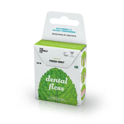 Detail van verpakking van The Humble Co. flosdraad met mintsmaak – met iconen voor vegan, xylitol en tandarts-ontworpen product; gerecycled karton en afbeelding van verse muntbladeren