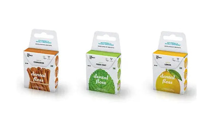 Drie verpakkingen van The Humble Co. flosdraad – kaneel, mint en citroen – elk in gerecycled karton met kleuraccenten die passen bij de smaak