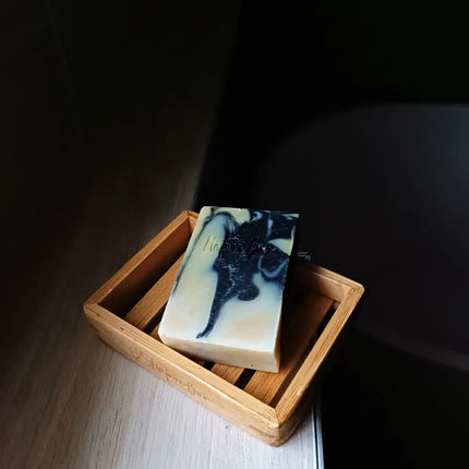 Natuurlijke houtskool zeep bar drogend op een houten zeepbakje