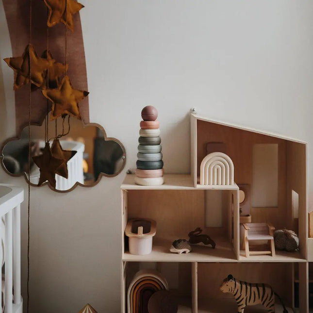 Sfeerbeeld van de Original Mushie stapeltoren met 7 ringen en sluitbal, geplaatst in een kinderkamer.