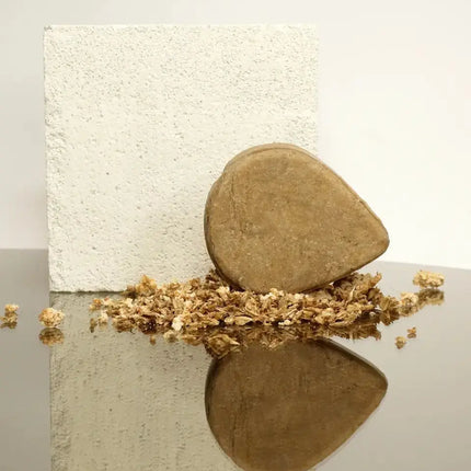 Vaste shampoo bar met bierbostel op een lichte achtergrond