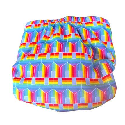 Achteraanzicht van de TotsBots zwemluier Hit The Hut, tonend hoe het geometrische regenboogpatroon en de elastische tailleband doorlopen.