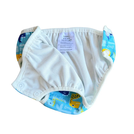 De opengemaakte wasbare baby zwemluier met de witte lekvrije binnenlaag en soepele beenmanchetten tegen lekken.