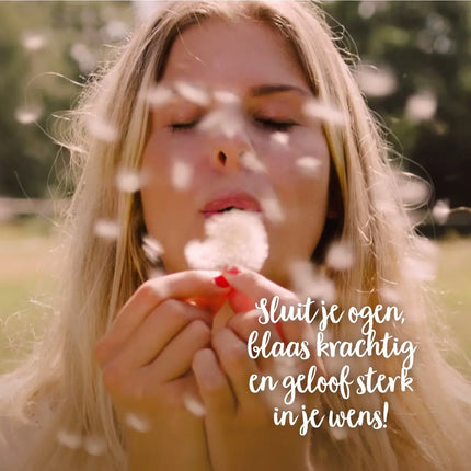 Vrouw die een wens doet met een paardenbloempluisje