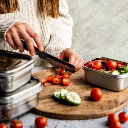 Persoon bereidt eten met Eco Brotbox Yumi lunchboxen op de achtergrond – praktisch in dagelijks gebruik